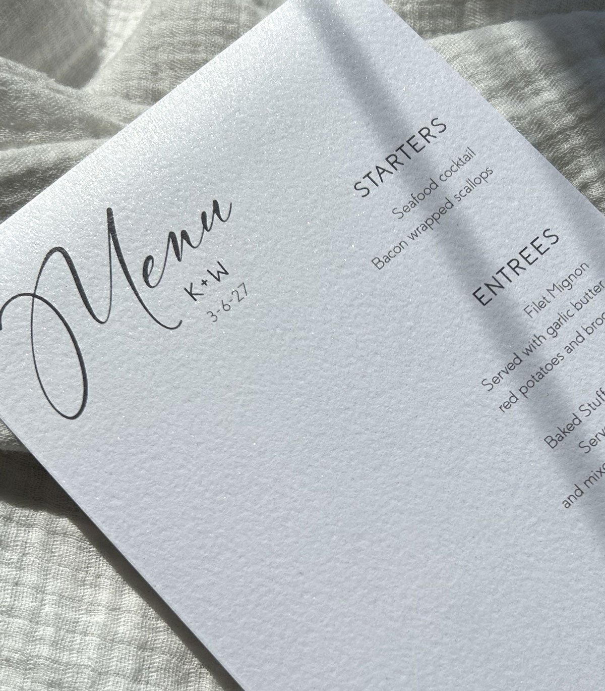 Simple white wedding menu card printed on shimmery textured paper